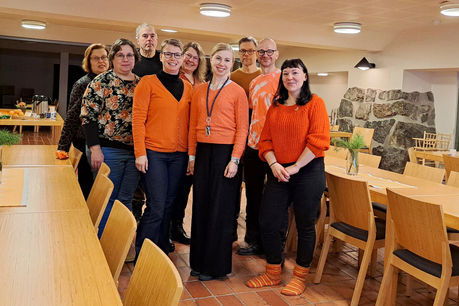 Ryhmä ihmisiä, joilla oranssit puserot.