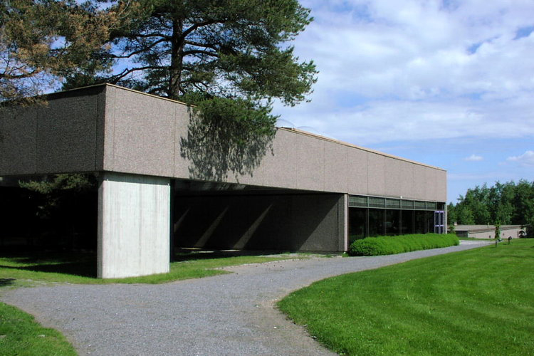 Grå fyrkantig byggnad på en gravgård.