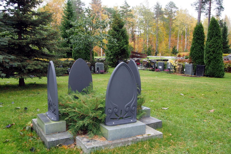 Fyra minnesmärken utplacerade i en ring med en buske i mitten.