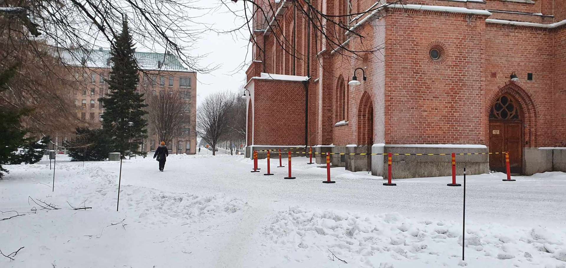 Ett område är avgränsat med bommar och band kring en röd tegelkyrka.