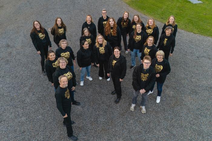 Grupp med människor står på en gård.