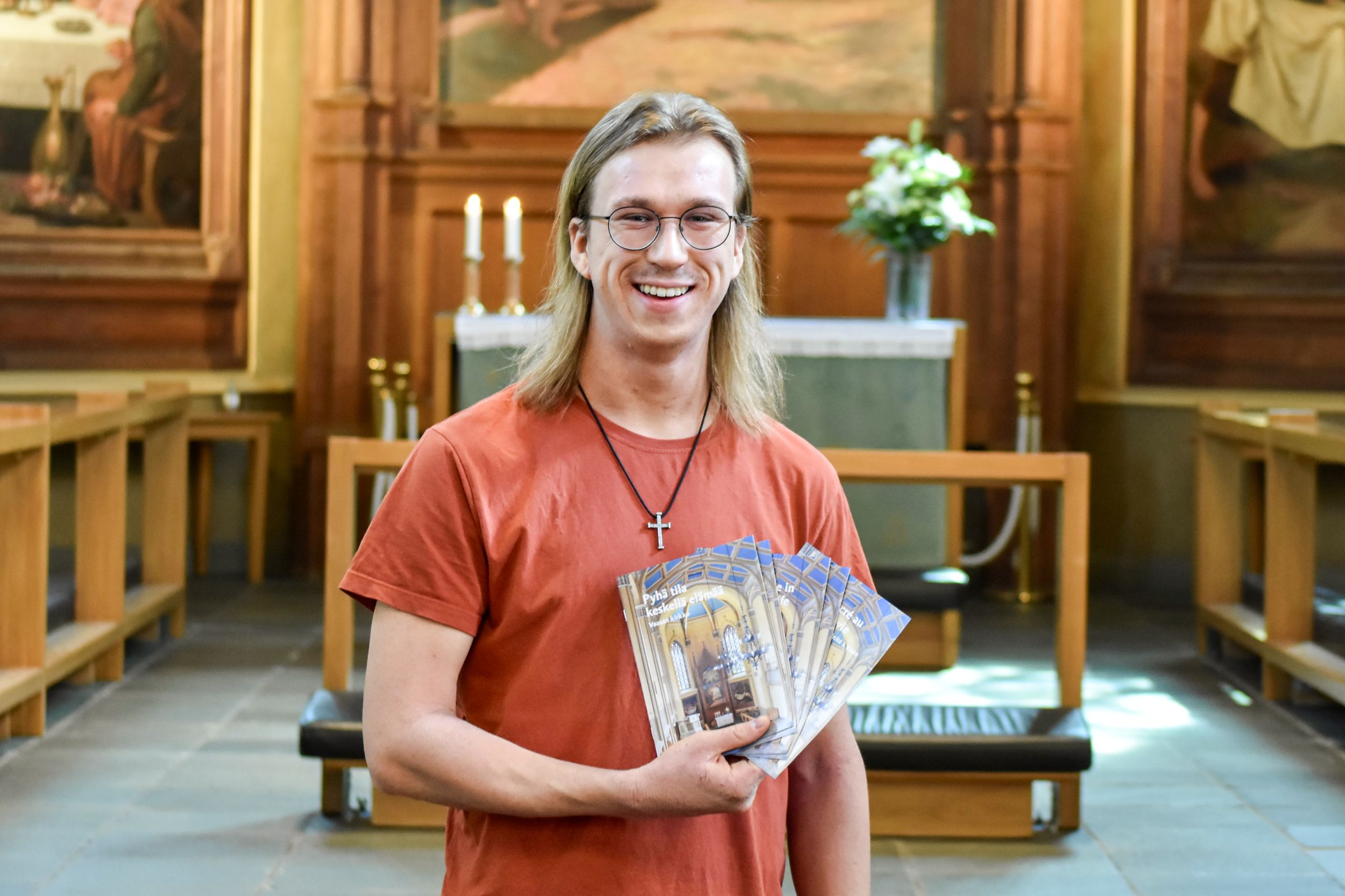 Man håller i broschyrer i en kyrka.