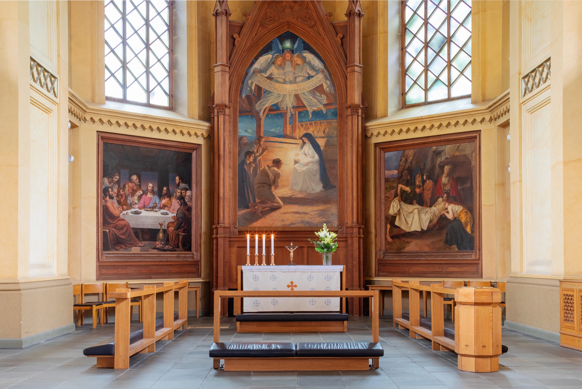 Altare och tre altartavlor i en kyrka.