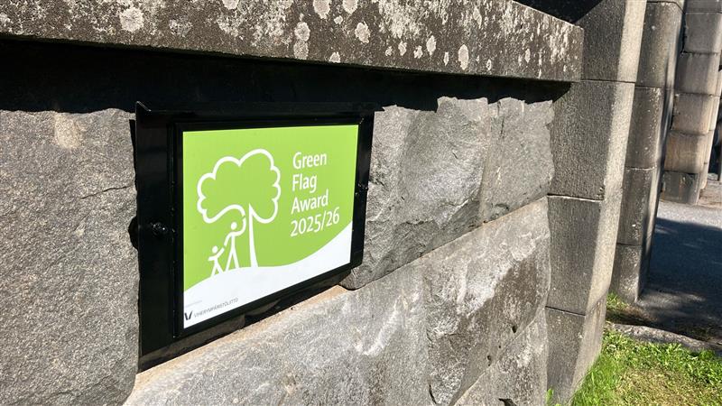 Grön skylt med texten Green Flag Award 2025/26.